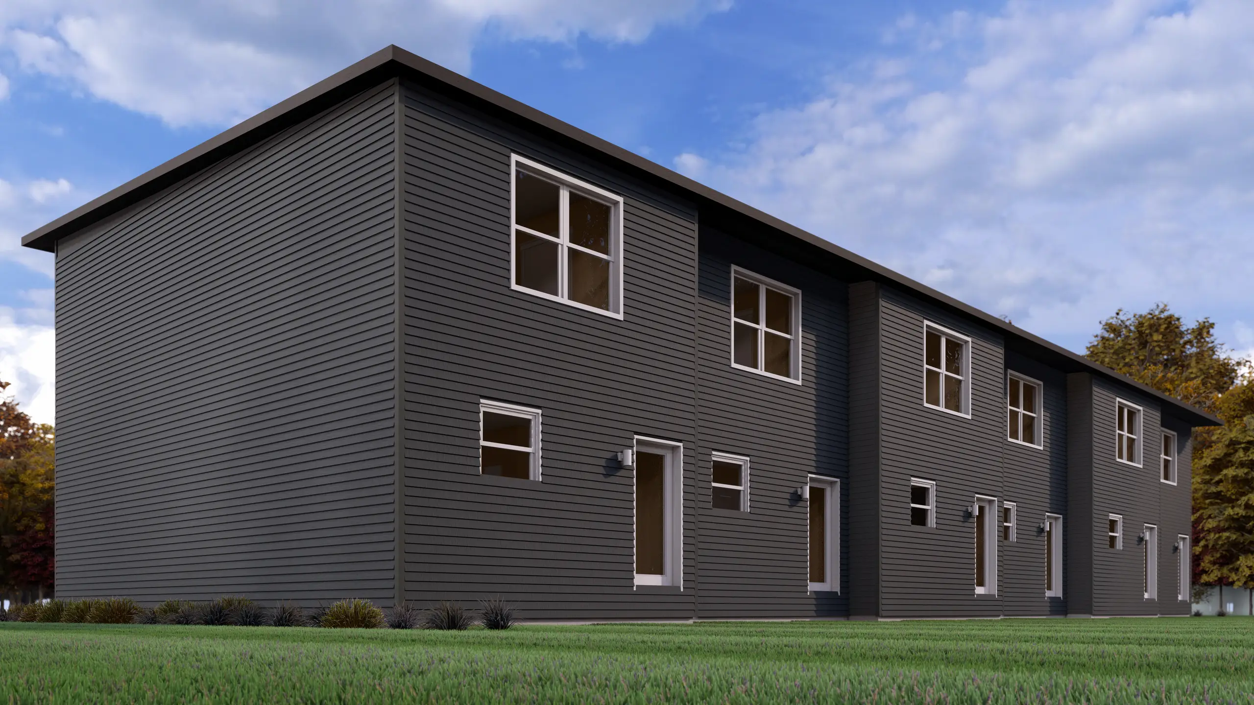 Rear view of a modern multi-residential building featuring durable dark exterior siding, multiple private entrances, and landscaped green space. 