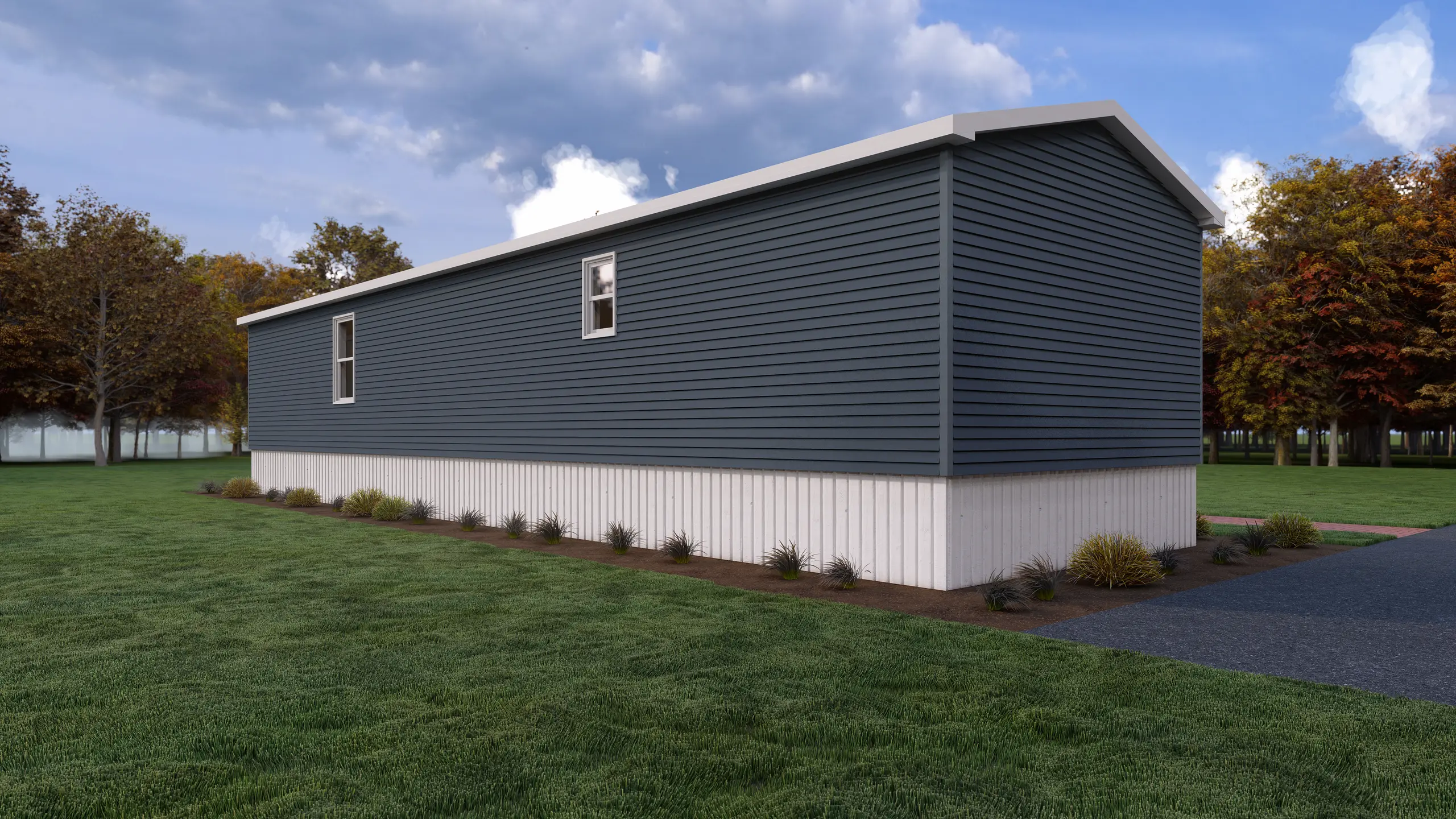 Rear corner view of a modular home featuring blue horizontal siding, white skirting, minimal side windows, and landscaped surroundings. 