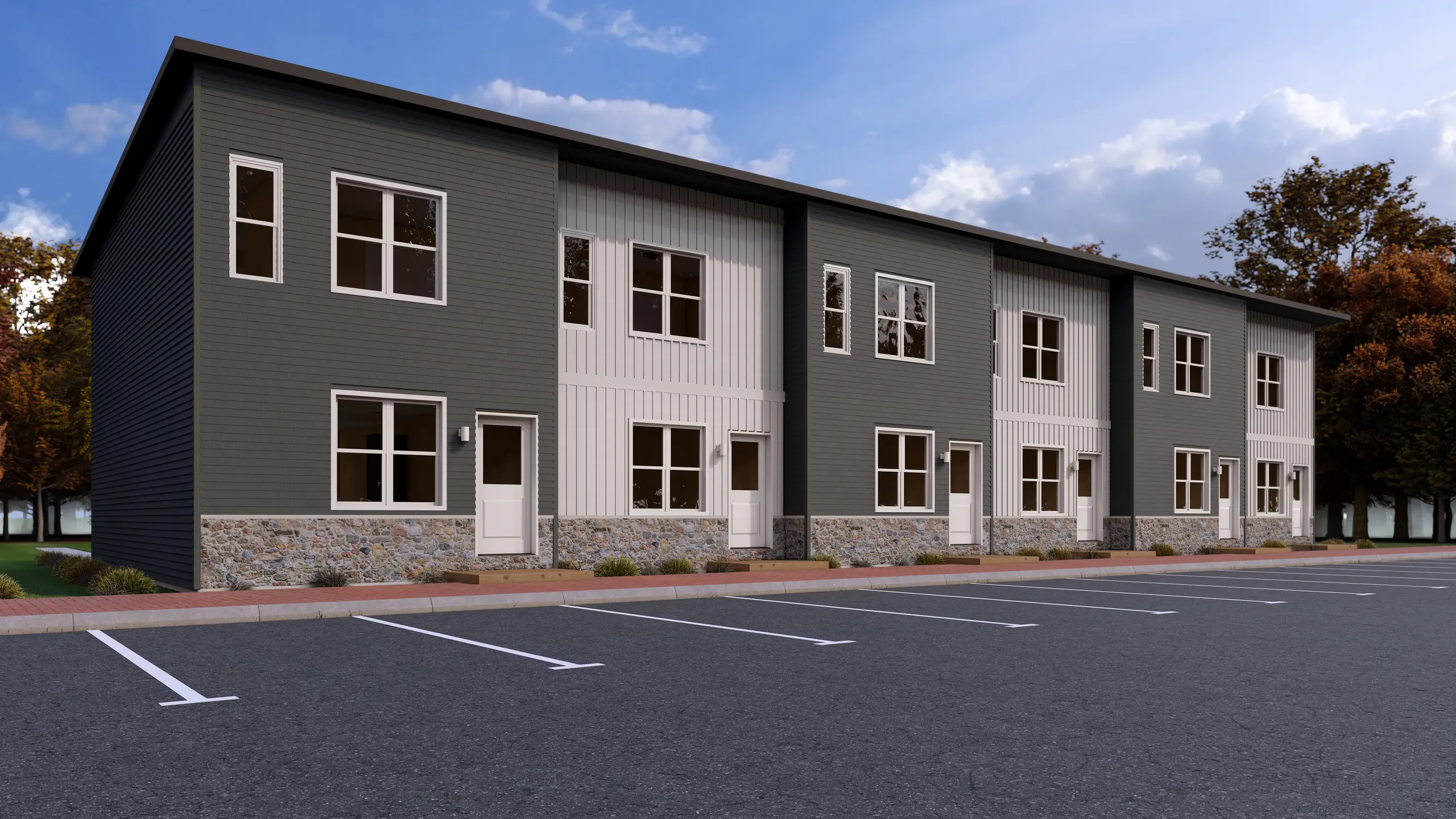 Contemporary multi-unit apartment building with dark grey and white siding, stone accents, individual unit entrances, and on-site parking. 