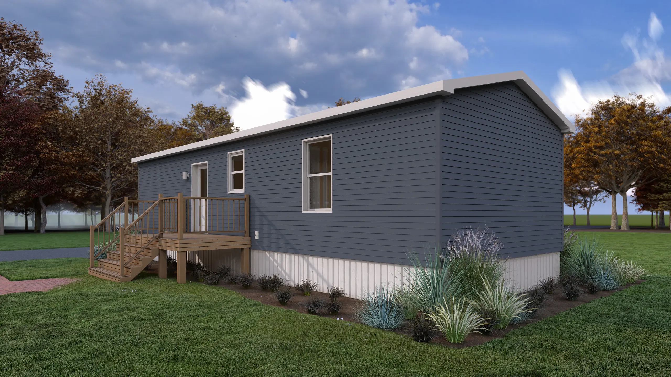 Rear corner view of a modern mini home featuring blue siding, an exterior entry deck with stairs, large windows, and landscaped surroundings. 