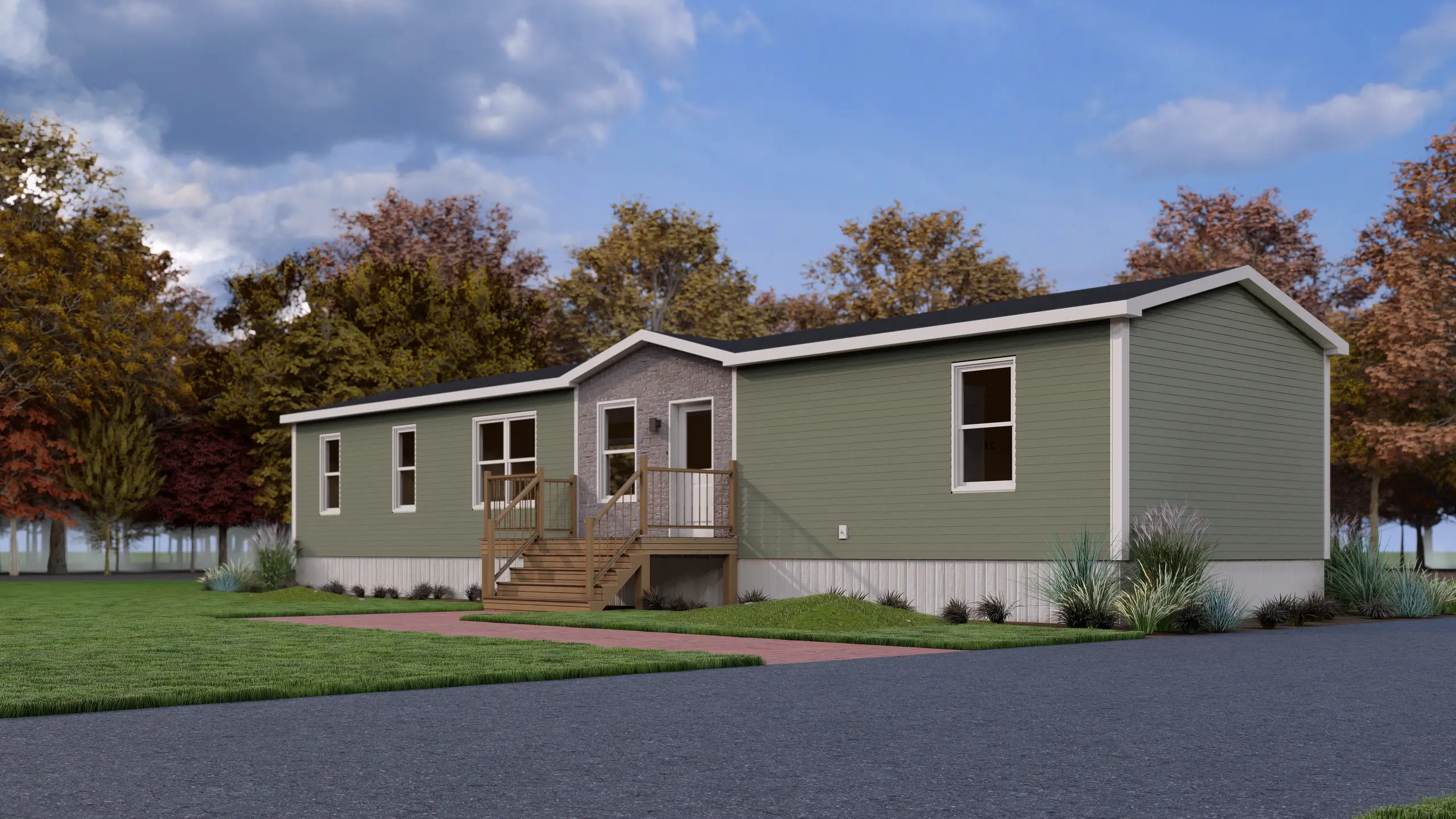 Front corner view of a contemporary mini home showcasing sage green exterior siding, a covered entry deck, white trim, and landscaped surroundings. 