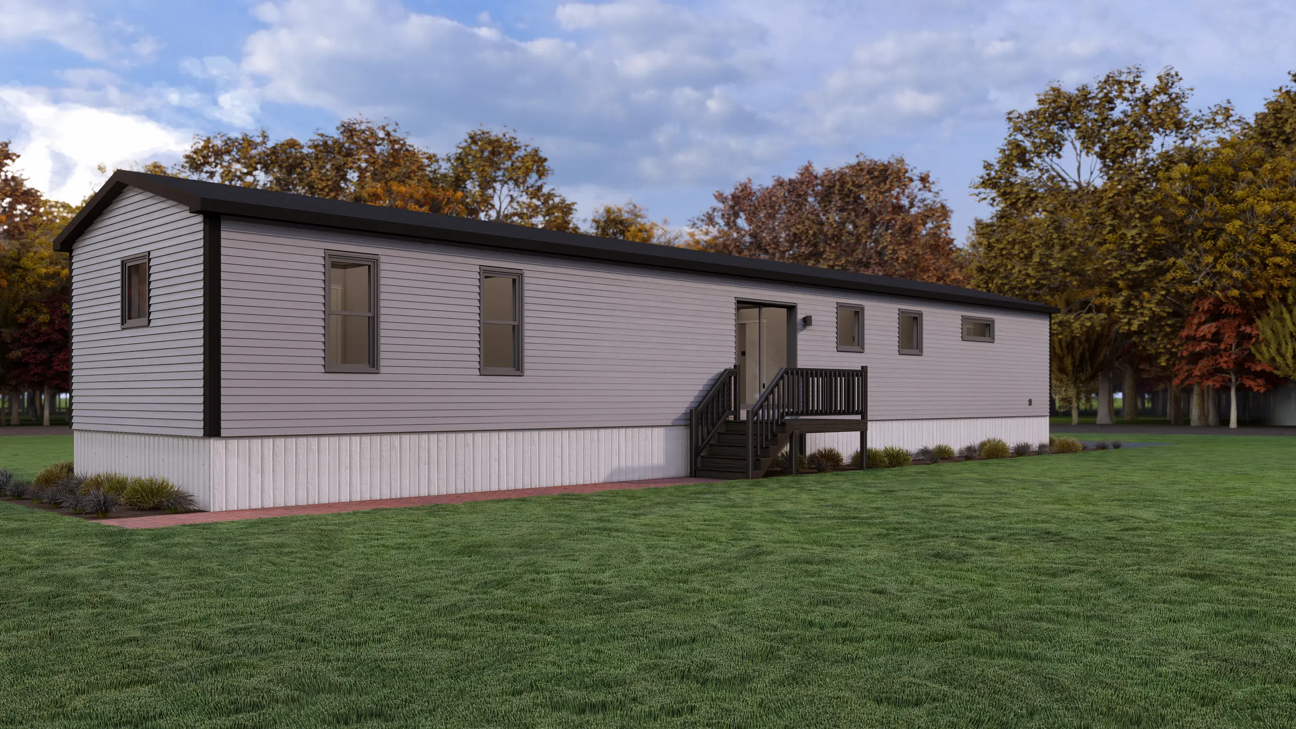 Side view of a modern modular home with light grey siding, a raised entry deck, narrow horizontal windows, and landscaped surroundings. 