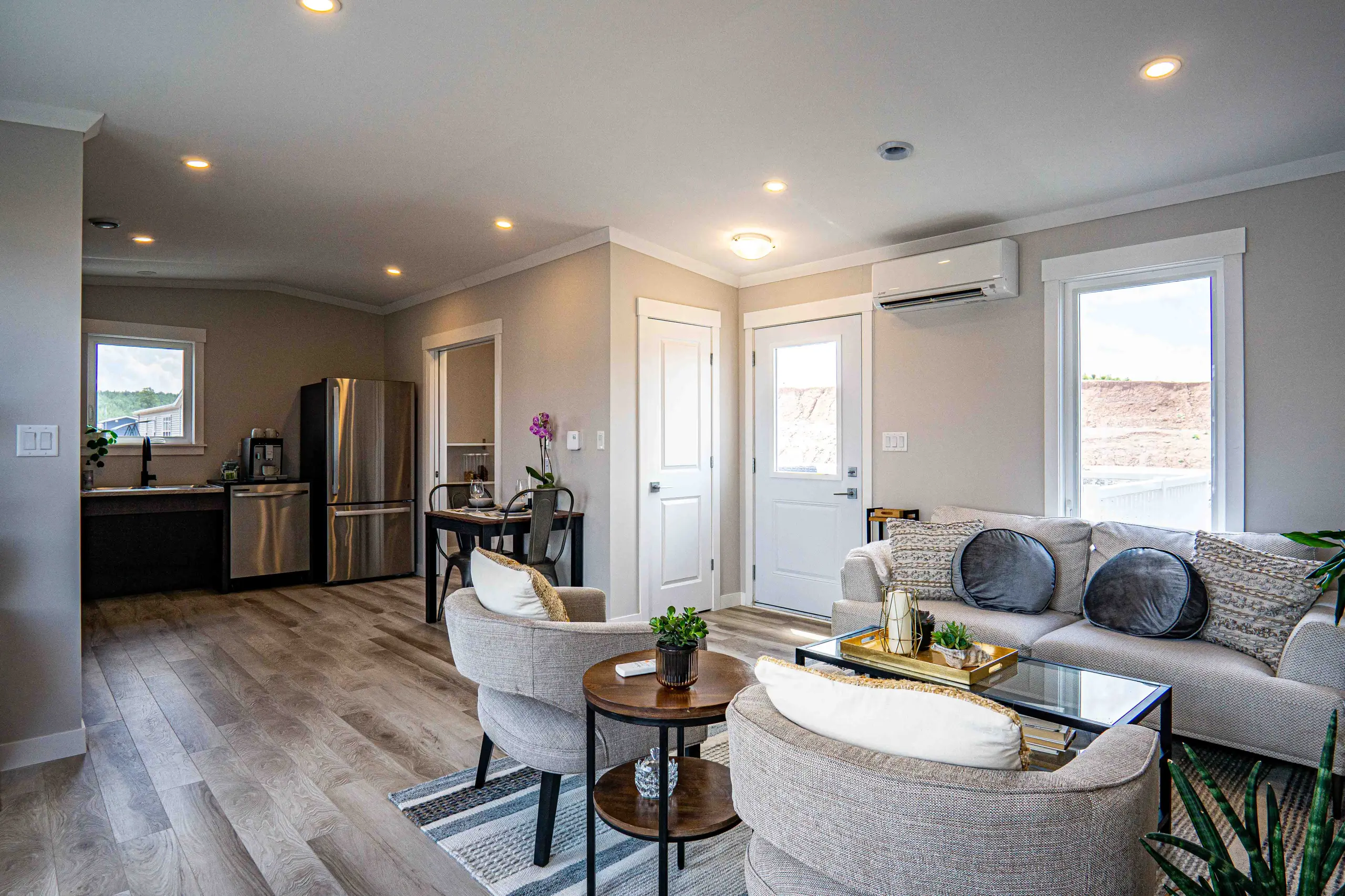 Spacious open-concept living and dining area seamlessly connected to the kitchen, showcasing wide-plank flooring and abundant natural light. 