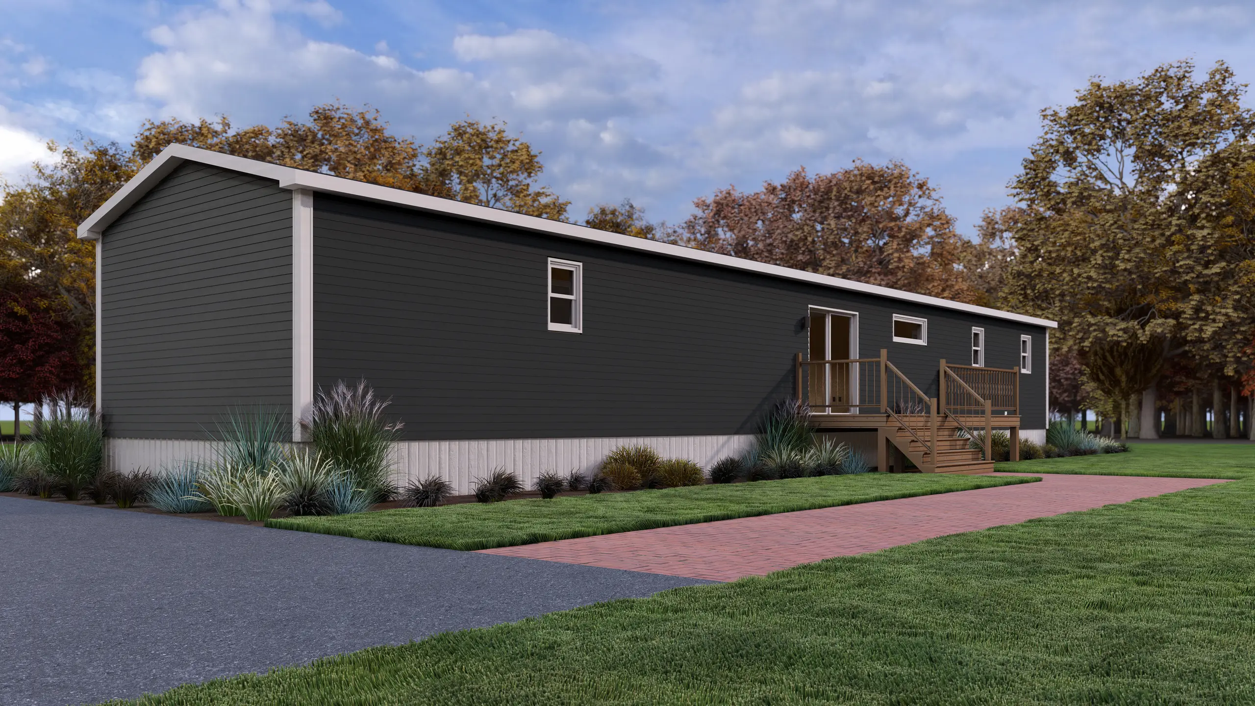Side view of a contemporary mini home with dark exterior siding, a spacious rear deck, patio door entry, and foundation landscaping. 