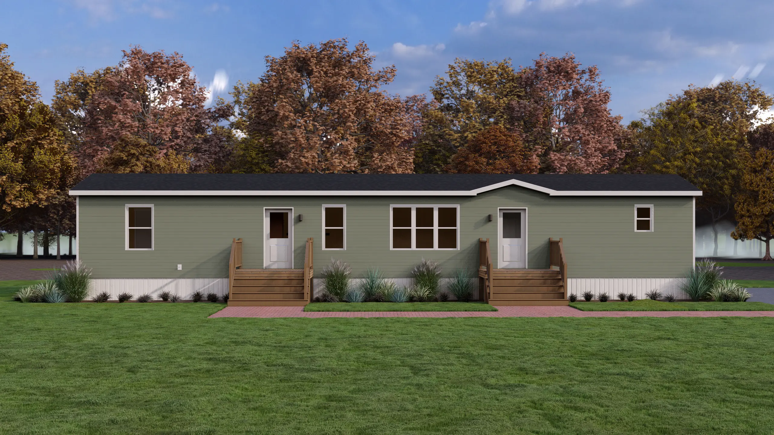 Single-section mini home with sage green siding, dual entry decks, white trim, and coastal-inspired landscaping with ornamental grasses. 