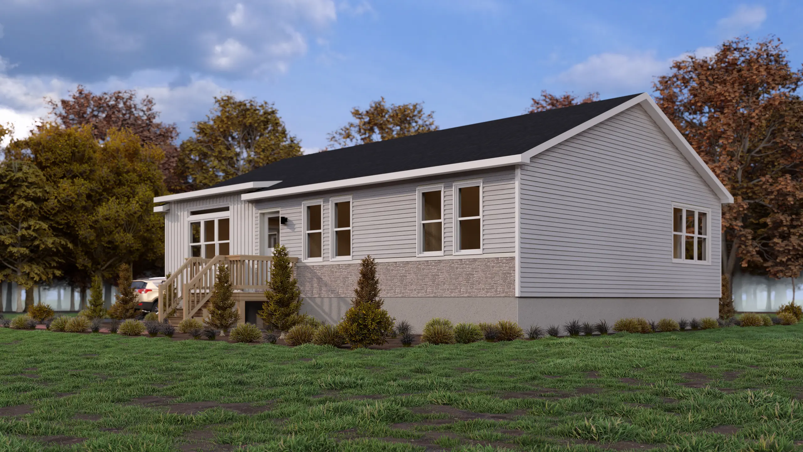 Side view of a light grey modular home with multiple windows, wood front deck, and landscaped foundation planting. 