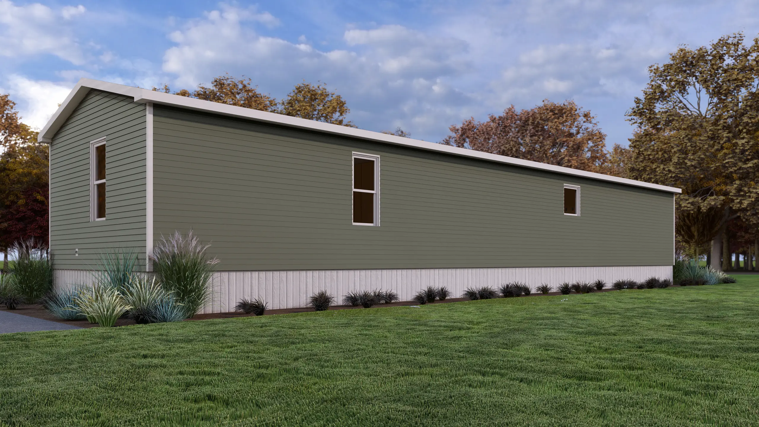 Rear corner view of a mini home featuring sage green siding, narrow windows, white trim, and landscaped foundation plantings with ornamental grasses. 