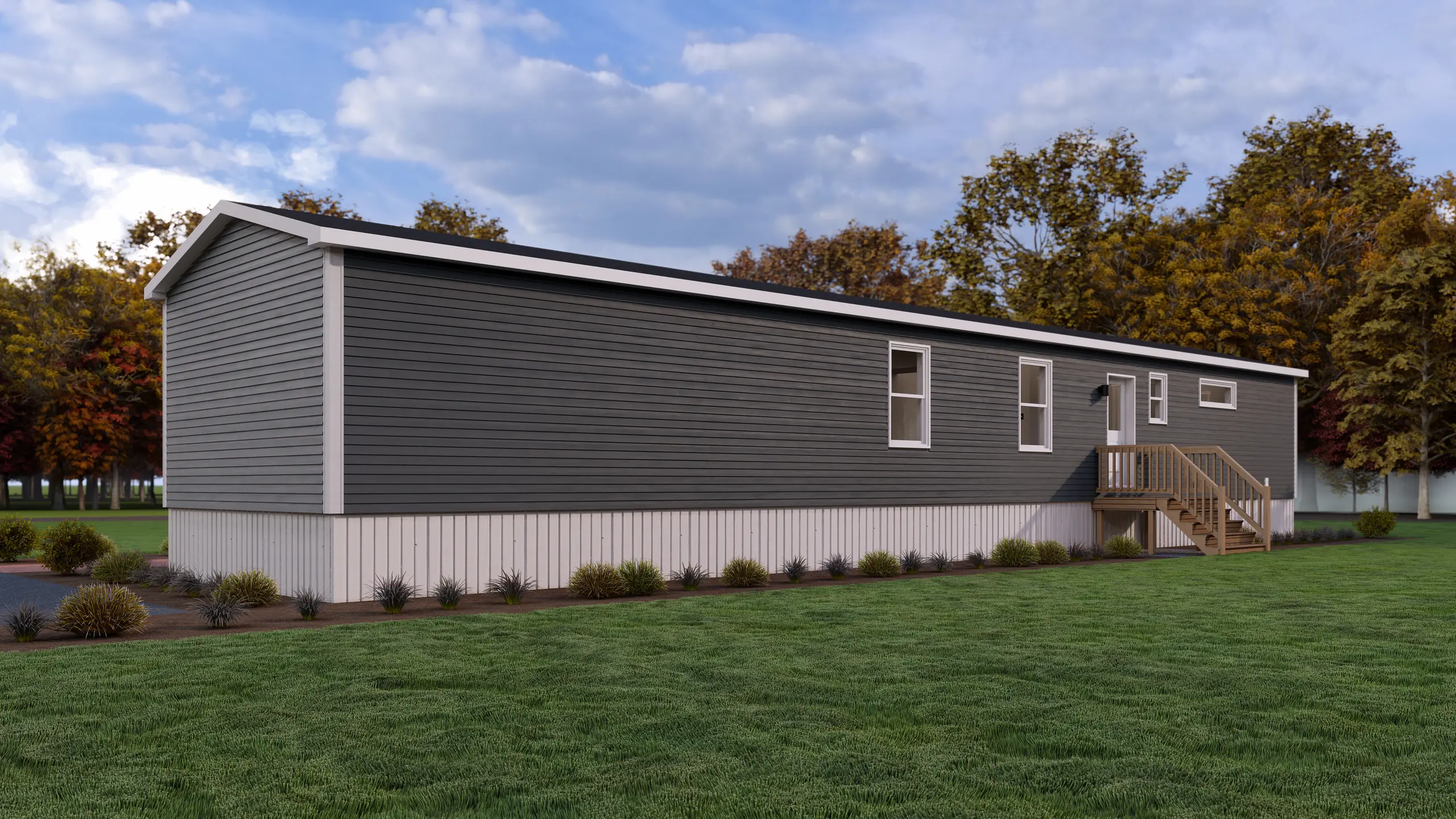 Long side elevation of a mini home with blue-grey siding, secondary entry deck, white trim, and low-maintenance landscaping. 