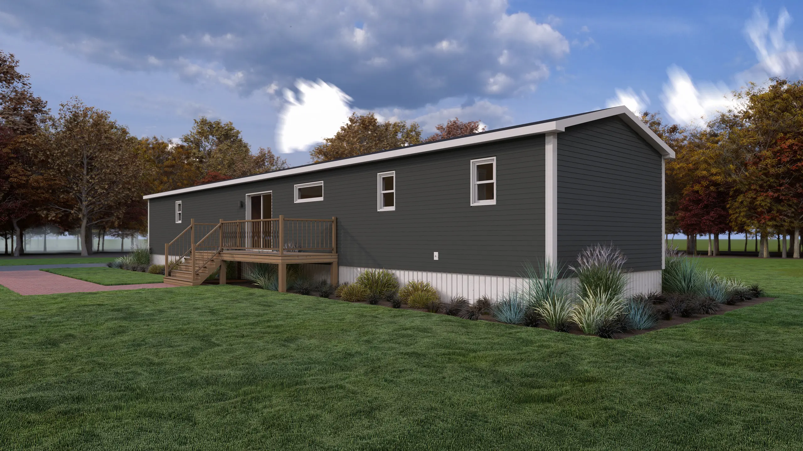 Rear corner view of a modern mini home featuring dark siding, a raised wood deck with patio door access, horizontal accent windows, and landscaped surroundings. 