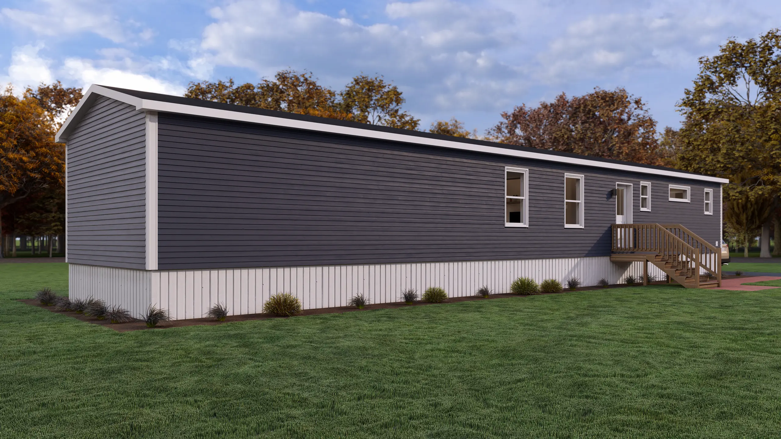 Long exterior view of a modern mini home with dark grey siding, side entrance, raised deck, and low-maintenance landscaping. 