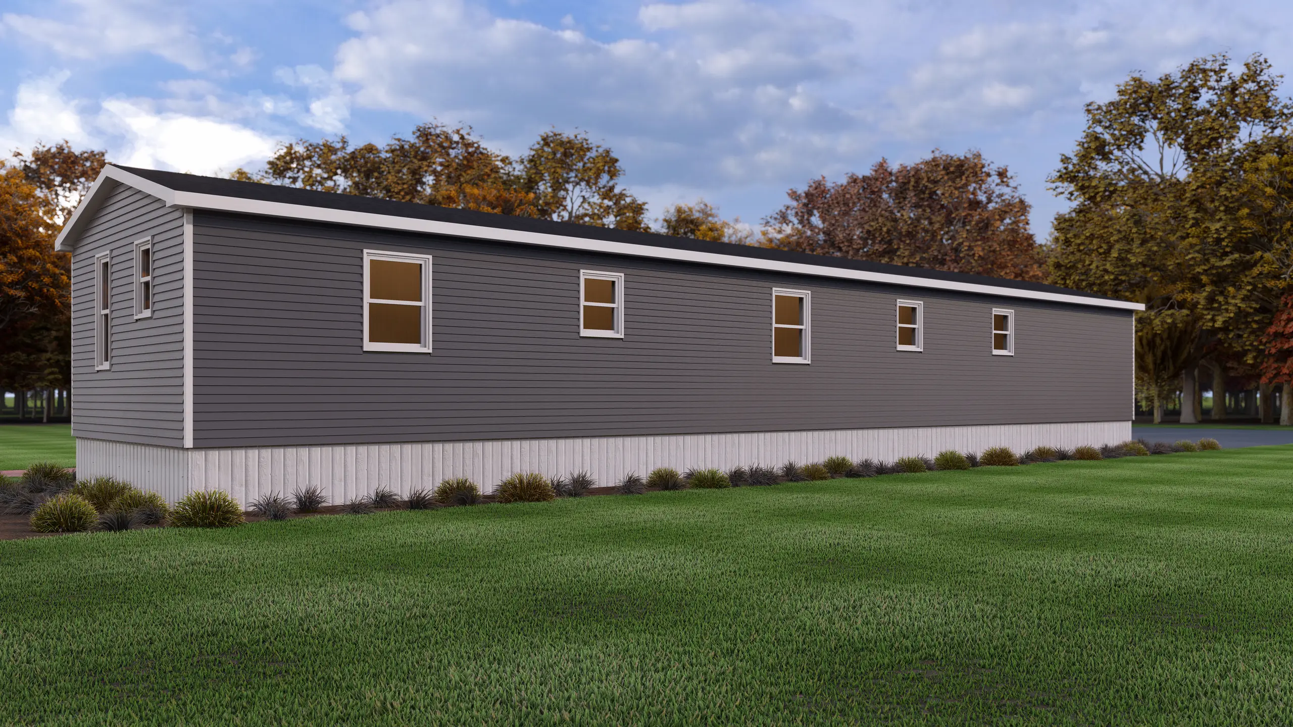 Side elevation of a contemporary multi-unit residential building with dark grey siding, multiple windows, landscaped perimeter plantings, and a low-maintenance exterior. 