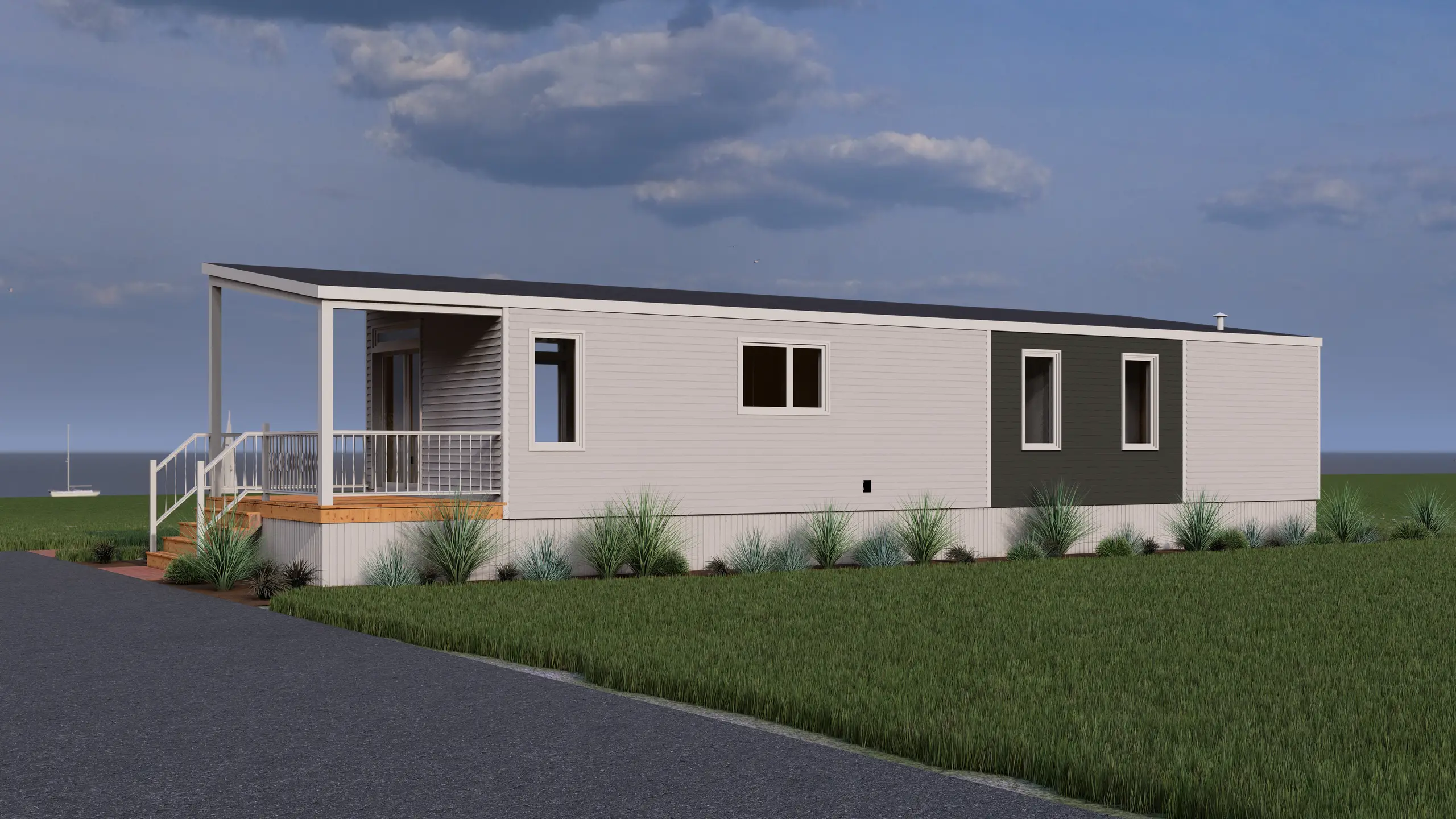 Modern single-section home with light grey siding, dark accent panel, sloped roofline, covered front porch, wood steps, railing system, foundation landscaping, and a paved driveway, set against a coastal backdrop with sailboats on the water. 