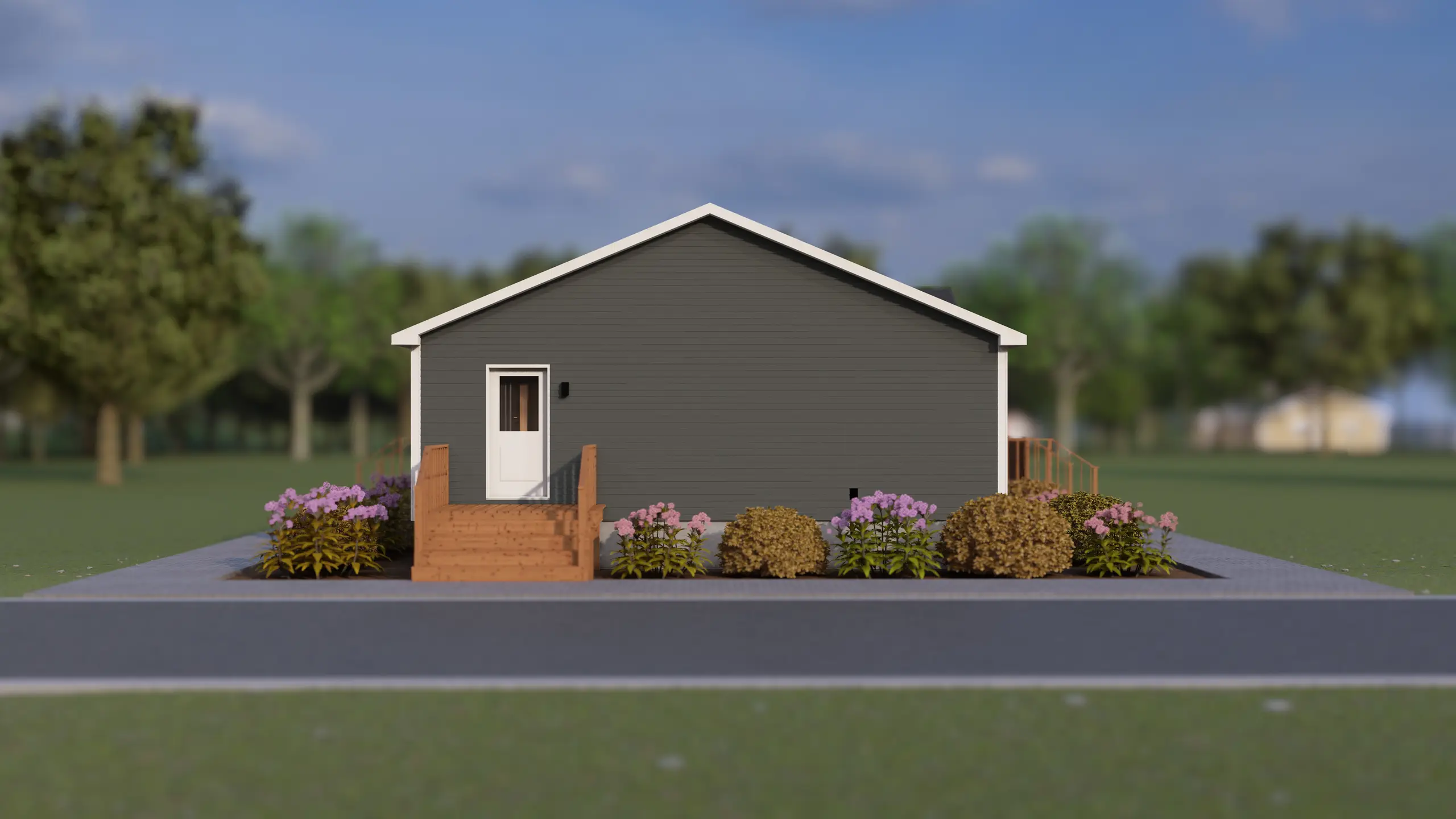 Side elevation of a modern bungalow with dark grey siding, a side entry deck, white trim, and landscaped flower beds along the home's exterior. 