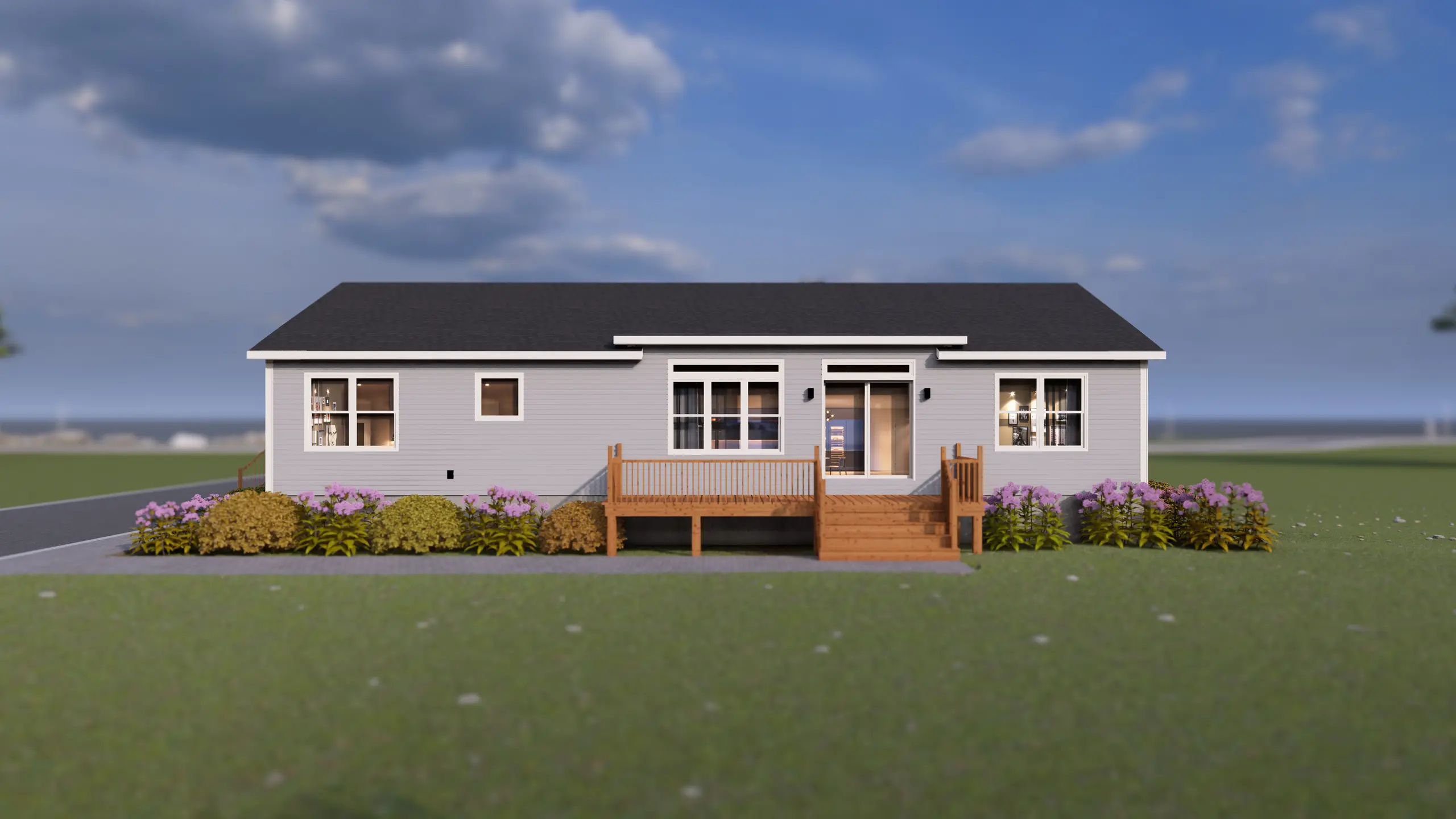 Side view of a modern bungalow with light grey siding, side entry steps, and landscaped flower beds along the foundation. 