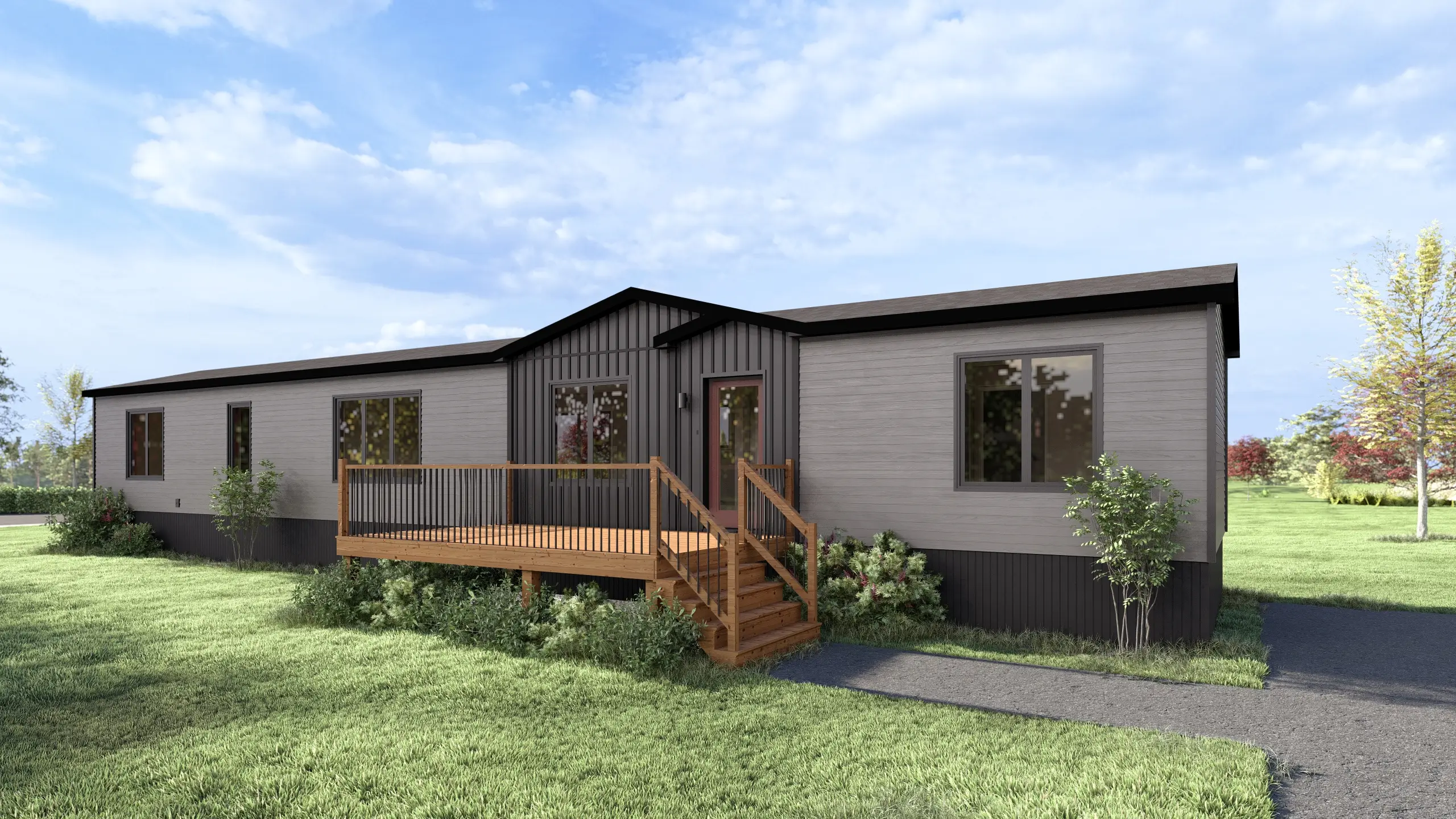 Front angled view of a contemporary mini home featuring light grey siding, a dark vertical accent façade, central entry deck, and landscaped garden beds. 