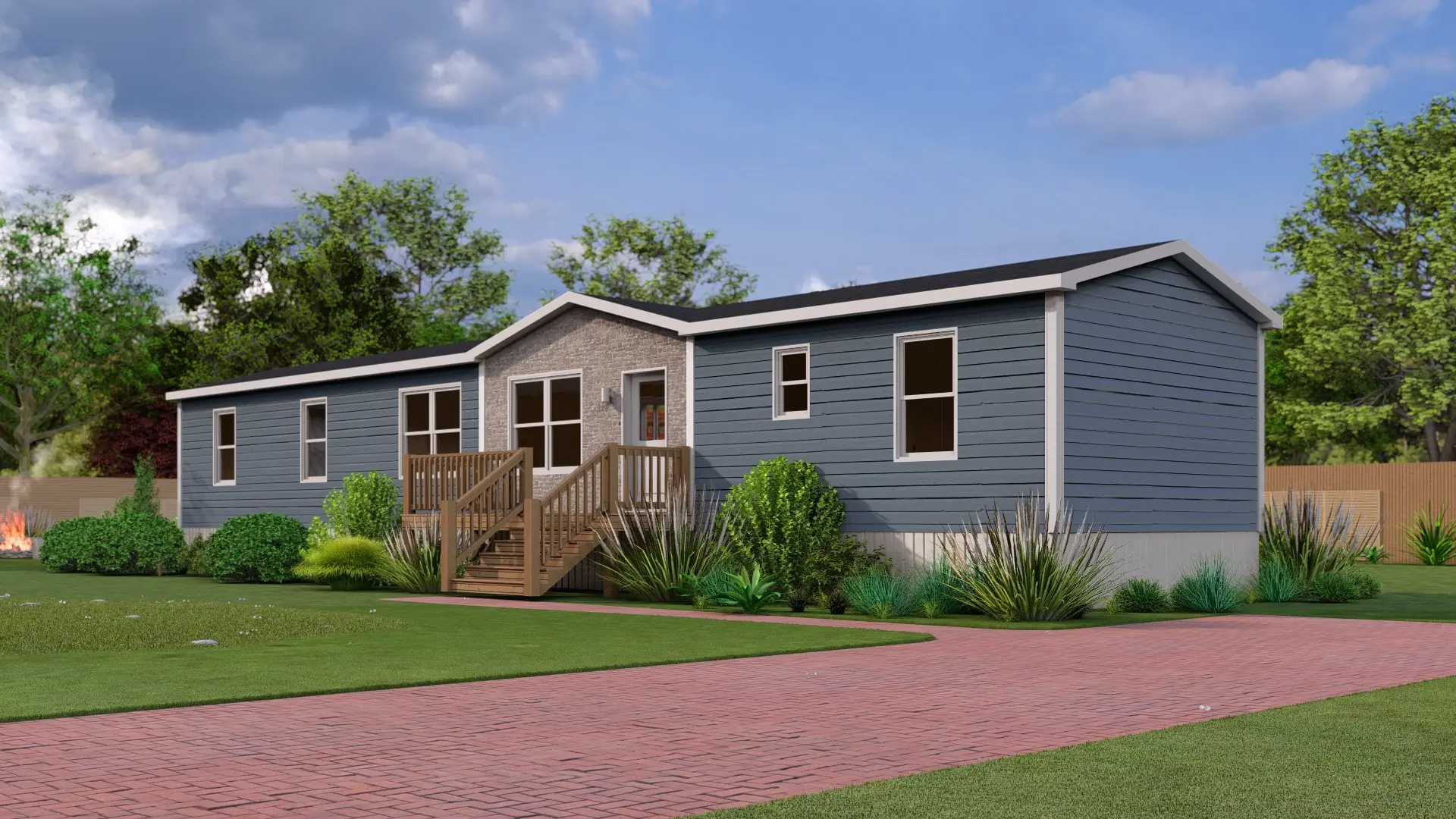 Front angled view of a modern mini home with blue exterior siding, a covered entry deck, large windows, and mature landscaping. 