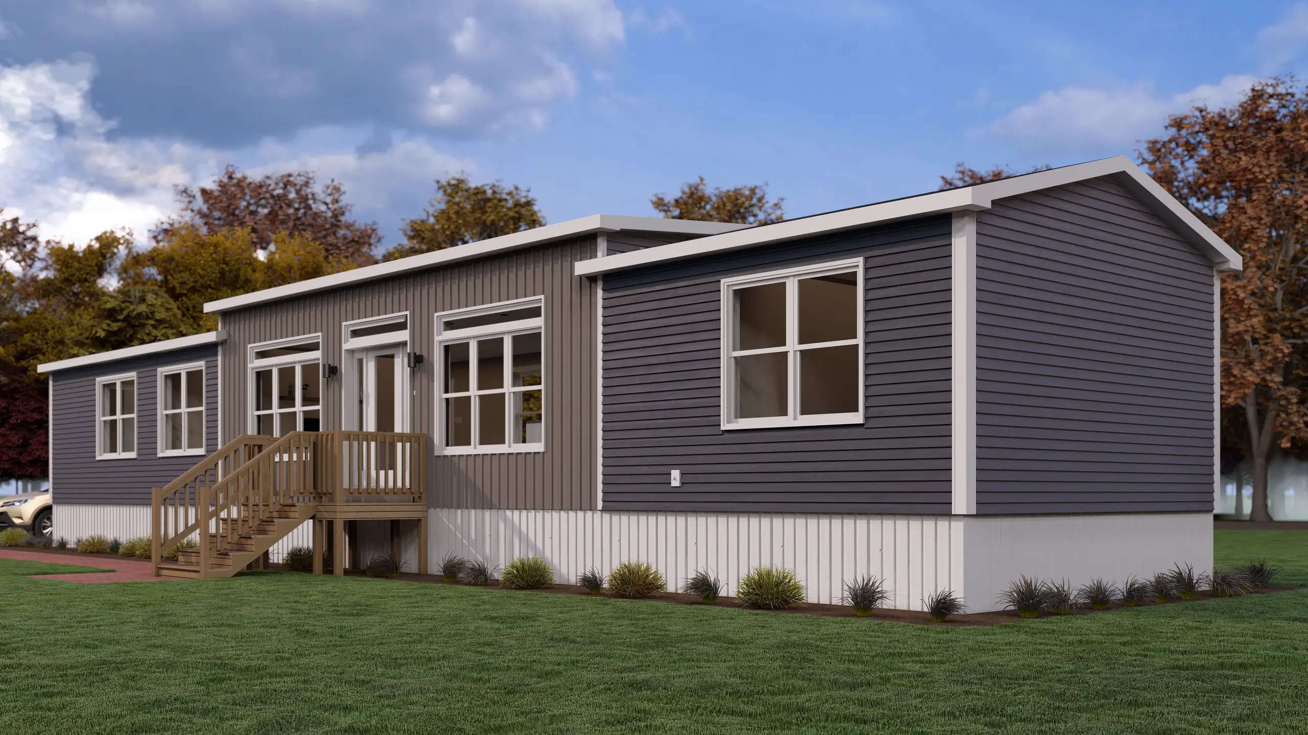 Modern mini home with dark grey siding, white trim, elevated front entry deck, large windows, and landscaped gardens. 