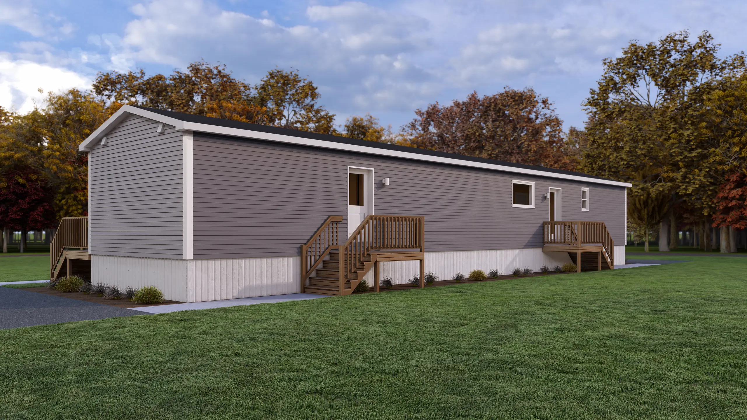 Rear view of a duplex-style residential building with private deck access, grey siding, low-maintenance exterior materials, and open green space. 
