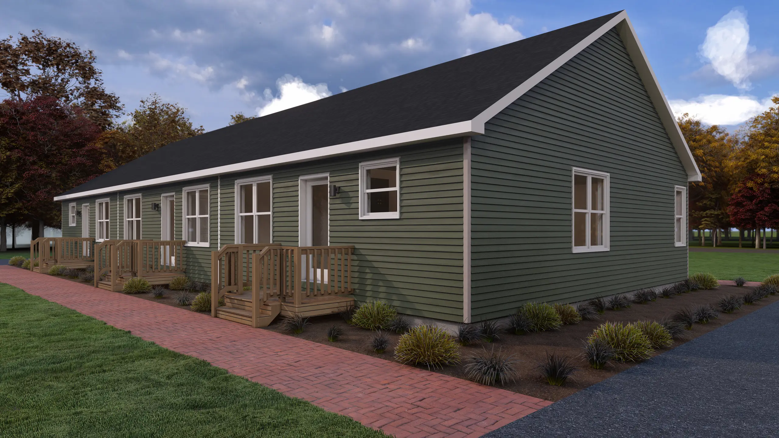 Angled view of a multi-unit housing development featuring green exterior siding, private porches, landscaped grounds, and a brick walkway. 
