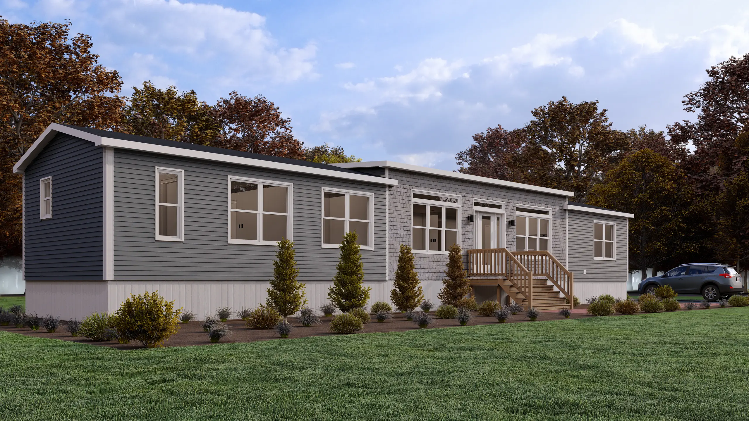 Contemporary mini home with blue-grey siding, a cedar shake accent façade, white trim, a central entry deck, and landscaped shrub beds. 